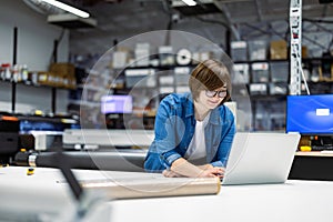 Woman using laptop at printing factory 